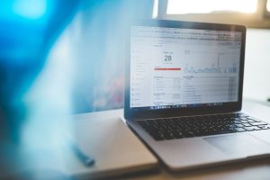 Laptop displaying a Google Analytics dashboard with charts in a modern workspace