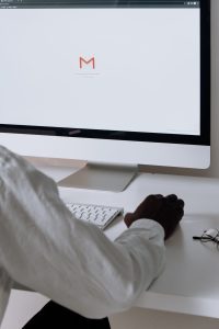 Professional checking a unified email inbox on a desktop computer screen
