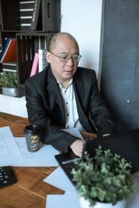Business owner working at his desk on a laptop with coffee