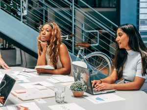 Marketing agency team collaborating on laptops at an office desk
