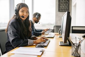 Smiling customer service representative wearing a headset at her desk